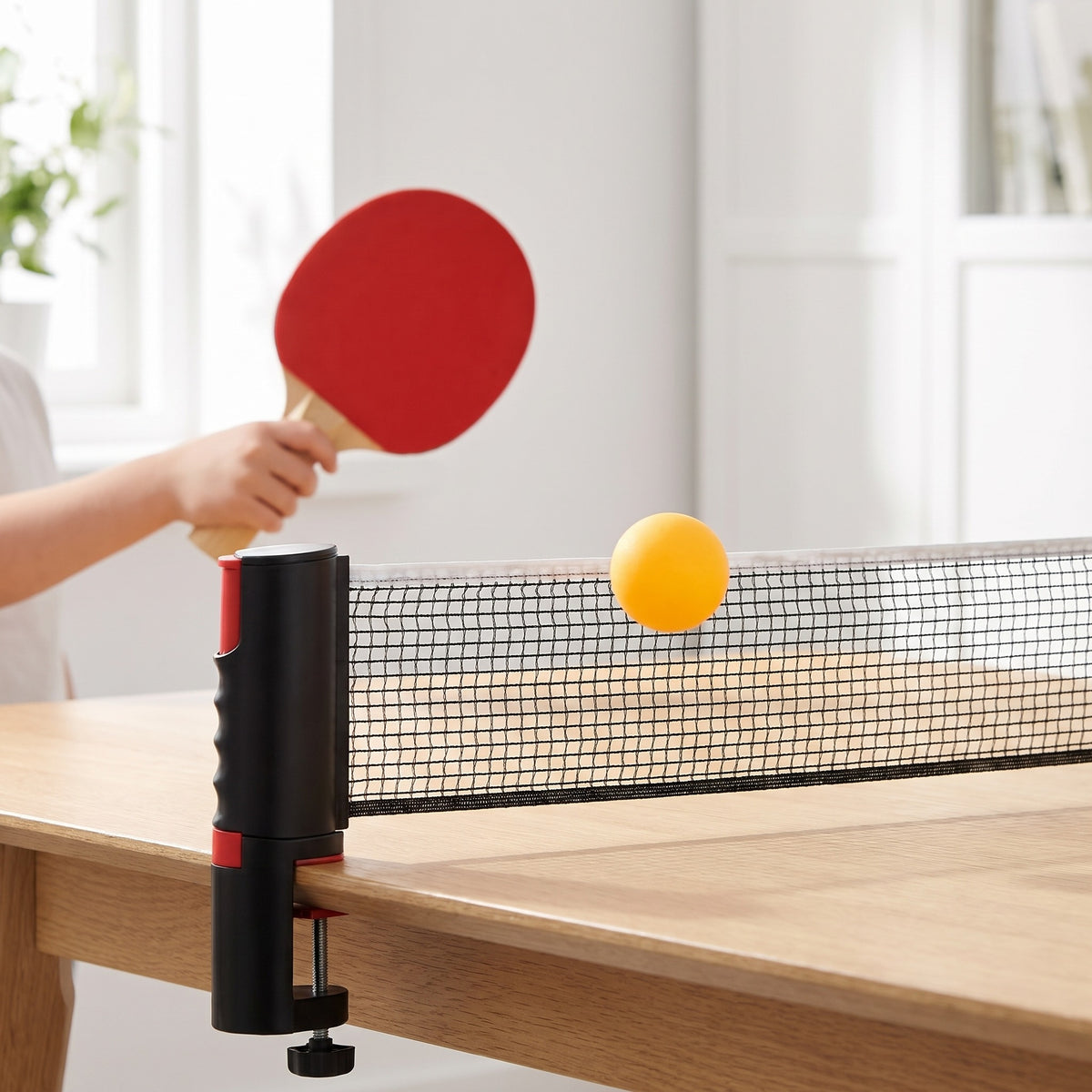 Gul pingisball i lufta over nettet på spisebordet